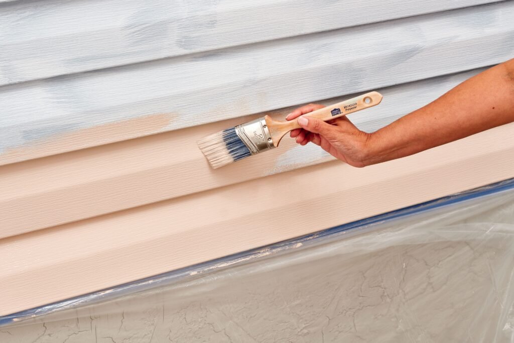 a brush painting a exterior vinyl siding by soca services
