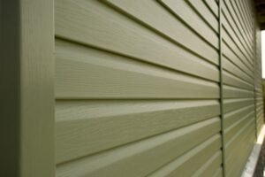 Green siding painting on a residential home by Soca Services