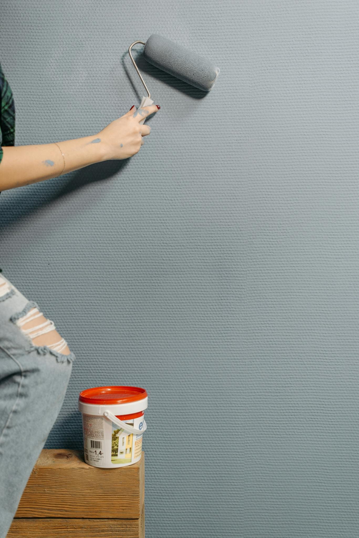 an adultt doing painting services on the walls
