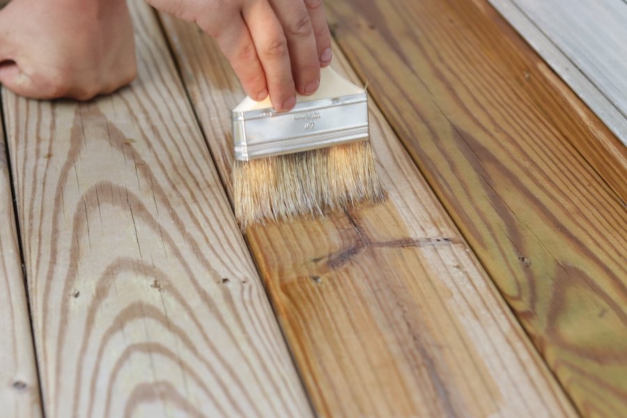 a brush stainig a exterior deck. outdoor painting