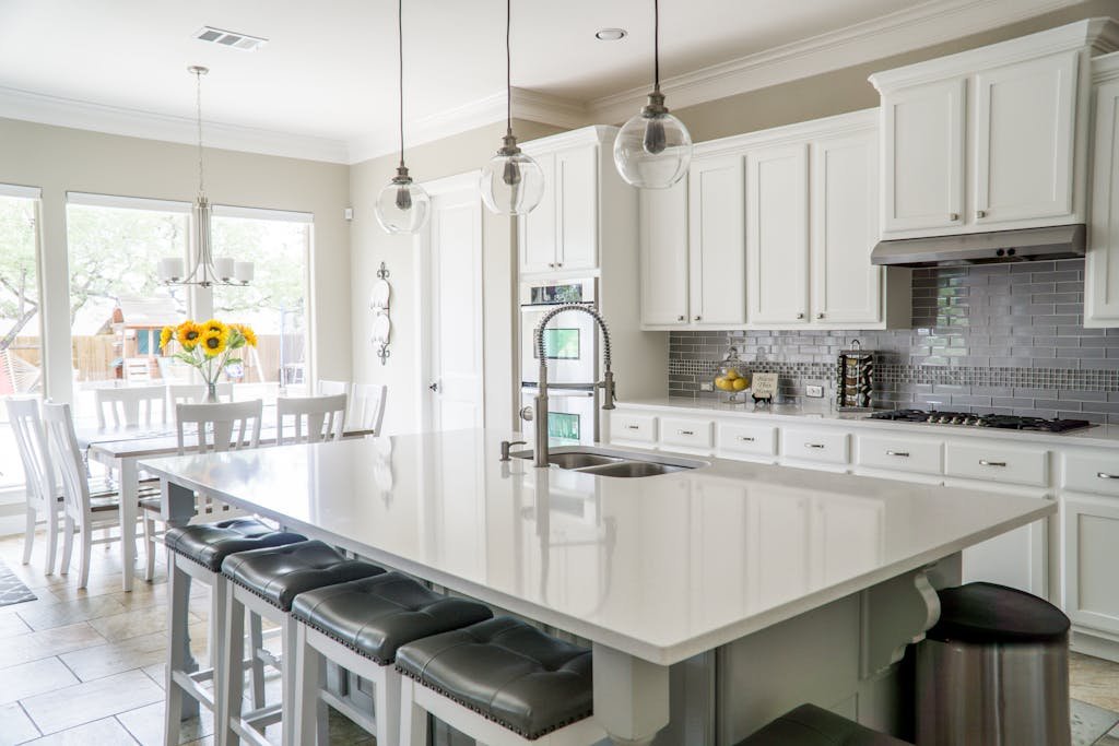 modern kitchen with white cabinets and island in natural light painted by soca services