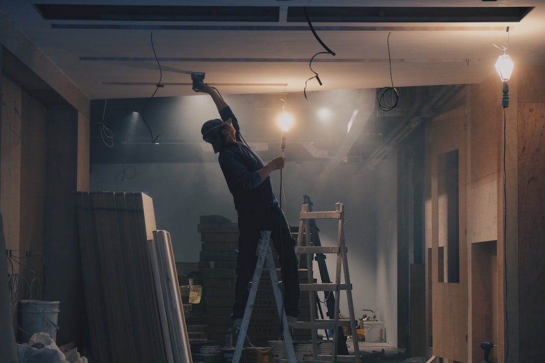 Professional contractor working on ceiling renovation with ladder in residential home interior. Photo by Unsplash