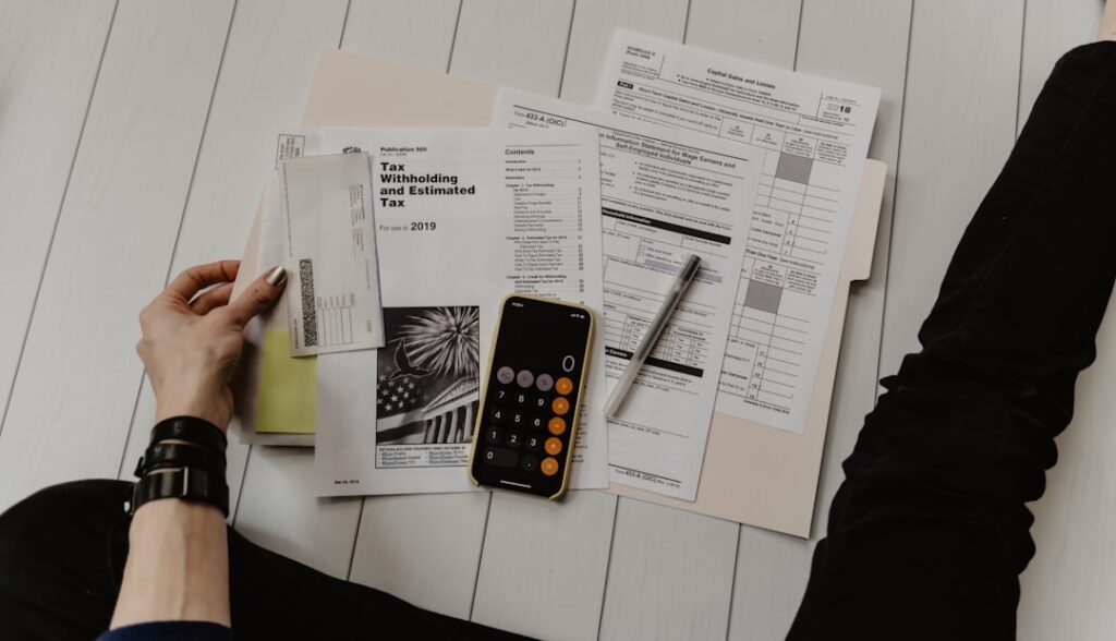 Person reviewing documents and using calculator for project cost estimation