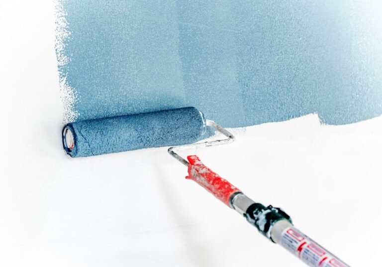 Professional interior painting with blue paint roller on white wall. Photo by Theme Photos on Unsplash