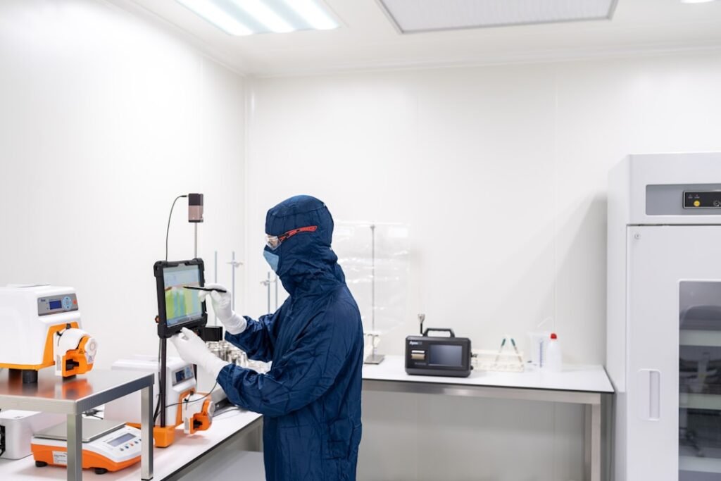 Laboratory technician in protective equipment analyzing material samples for asbestos testing