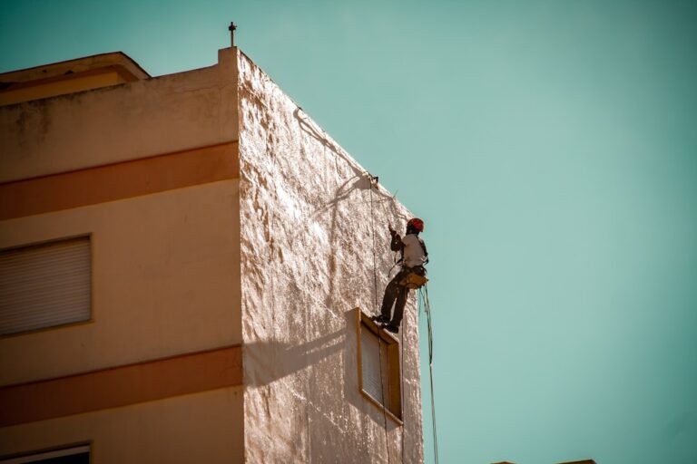 Professional painter on ladder working on exterior house painting project