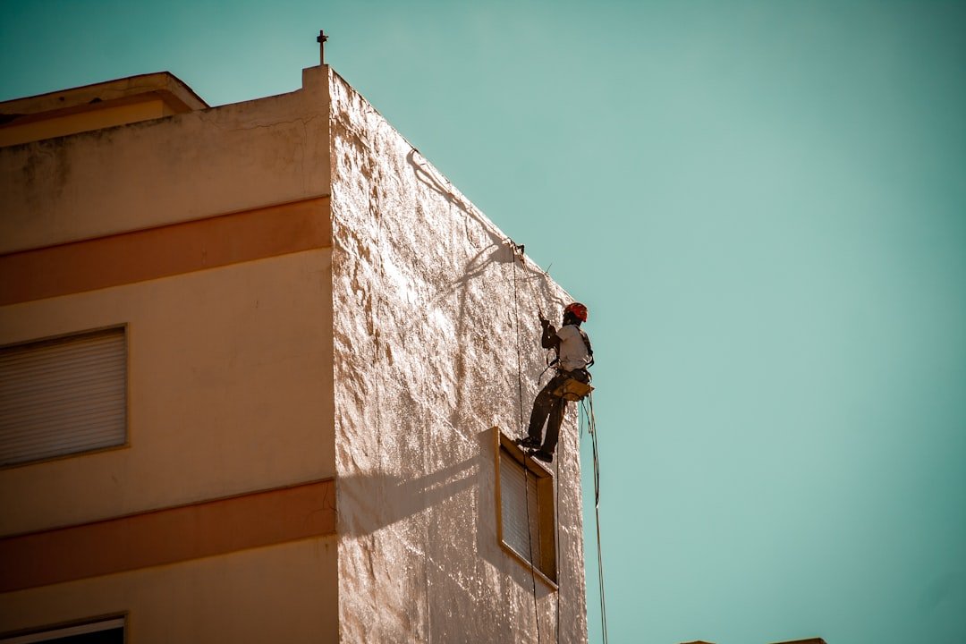 Professional painter on ladder working on exterior house painting project