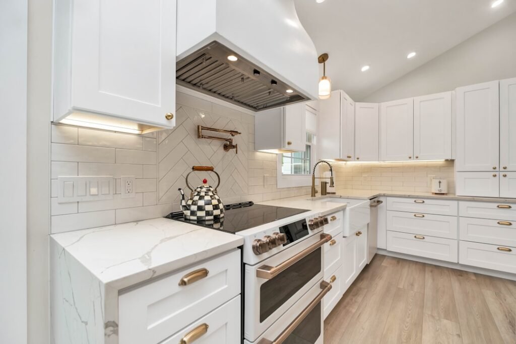 Modern kitchen with professionally painted white cabinets showcasing cabinet refinishing services in Toronto