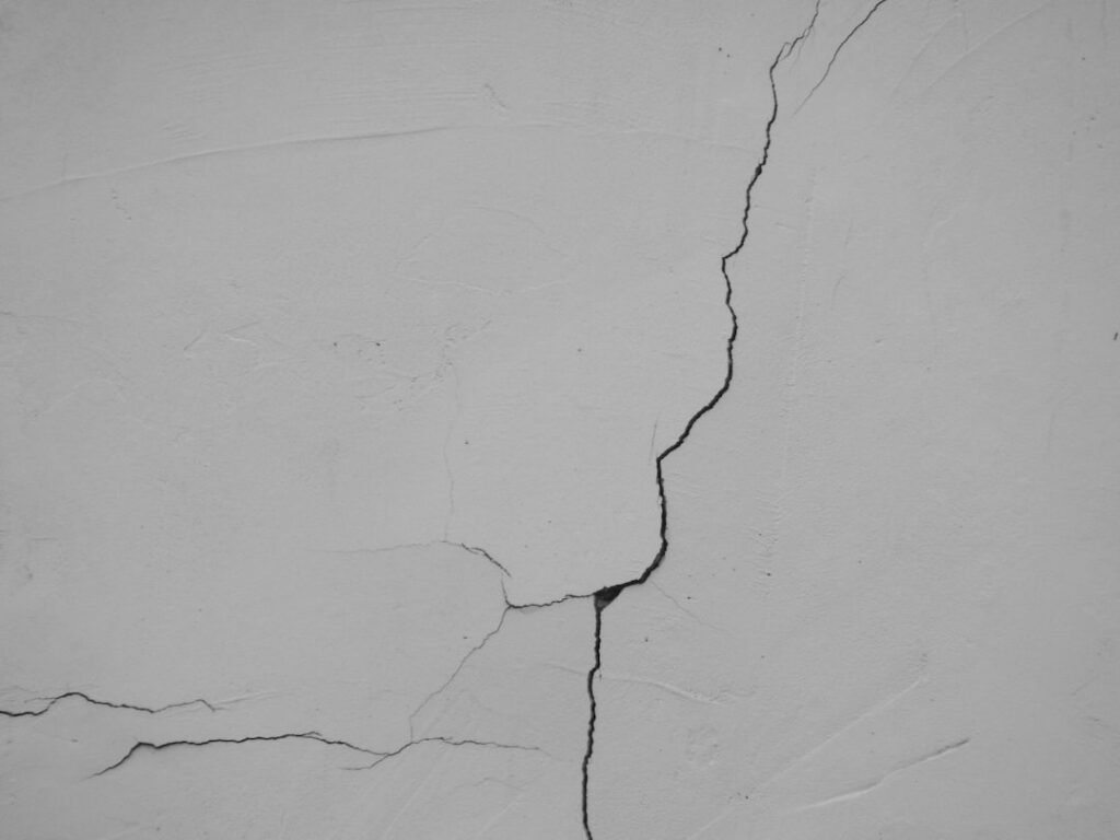 Crack in white plaster wall showing need for repair before painting