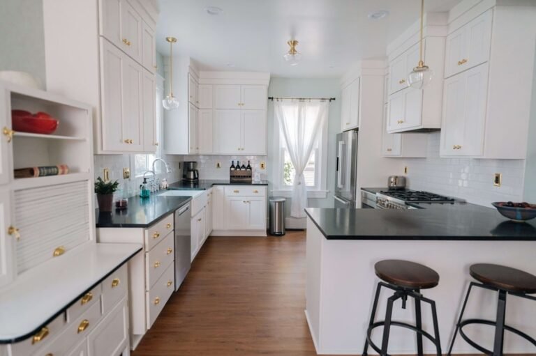 Modern kitchen with white painted cabinets showing the result of professional cabinet painting