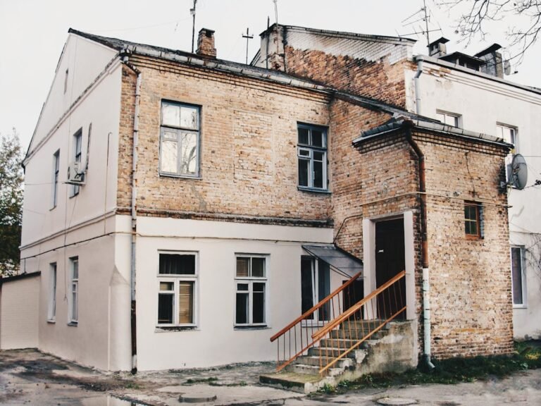 House exterior showing both painted white brick and natural brick sections, demonstrating the contrast between painted and unpainted masonry. Photo by Anton Mislawsky on Unsplash
