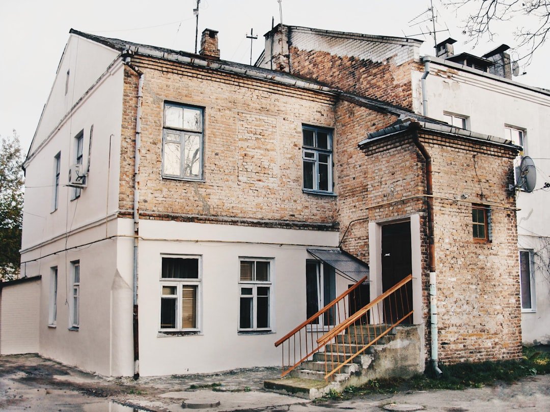 House exterior showing both painted white brick and natural brick sections, demonstrating the contrast between painted and unpainted masonry. Photo by Anton Mislawsky on Unsplash